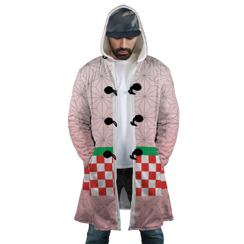 A man wearing the Nezuko Kamado Demon Slayer Dream Cloak Coat with a geometric pink pattern, red-and-white checkerboard pockets with green tops, black loop closures, over a white t-shirt and jeans.