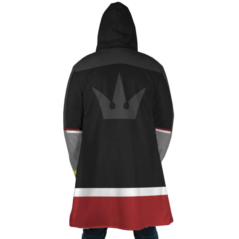Someone seen from behind wearing the Sora Kingdom Hearts Dream Cloak Coat—a hooded black coat with gray shoulders, red and white stripes at the bottom, and a gray crown emblem on the back.