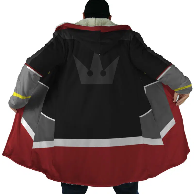 A person stands with their back to the camera, holding open the Sora Kingdom Hearts Dream Cloak Coat—black, red, and gray with a crown emblem on the back—to reveal its inner lining and design.