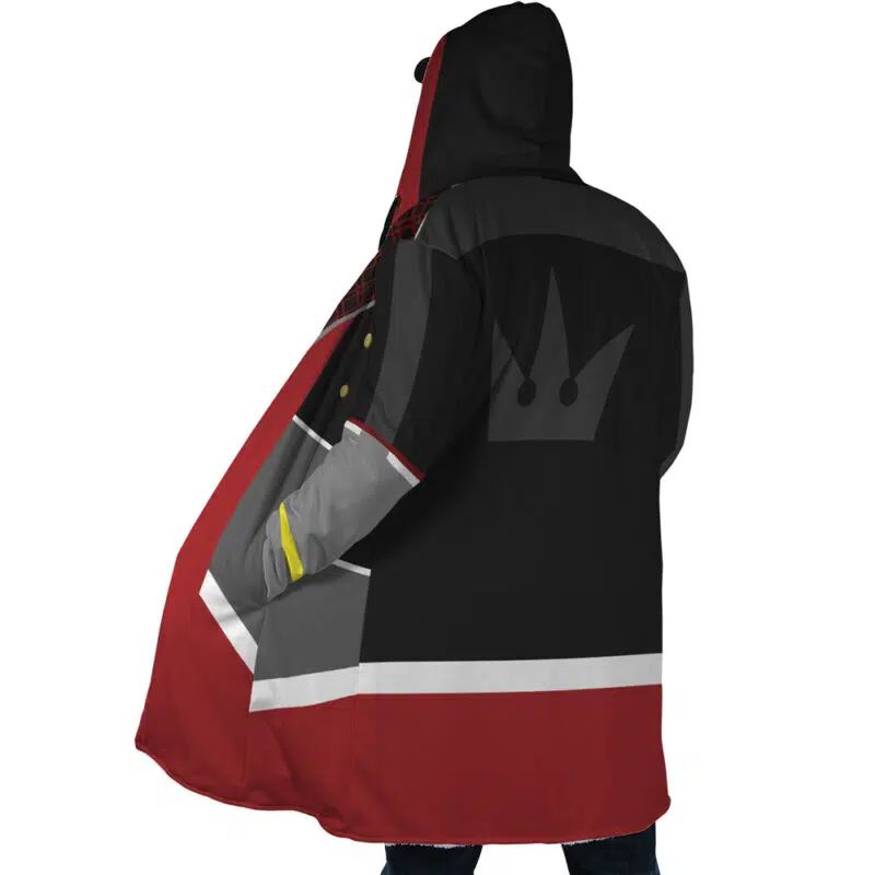 A person wearing the Sora Kingdom Hearts Dream Cloak Coat, an oversized hooded cloak in red, black, gray, and white with a large crown emblem on the back, stands with their back to the camera.
