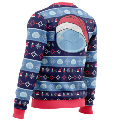 The Slimy Christmas That Time I Got Reincarnated as a Slime Christmas Sweater features blue and red festive patterns with snowflakes, Santa hats, and geometric shapes. A grumpy face in a Santa hat is illustrated on the back; cuffs, collar, and hem are bright red.