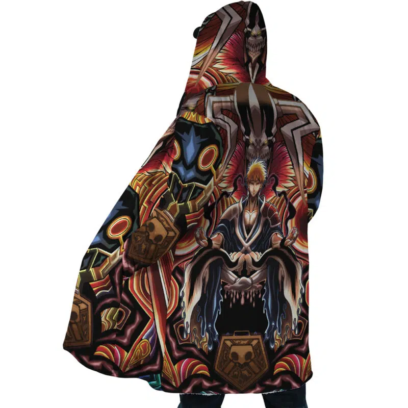 A person wearing the Ichigo True Shikai Bleach Dream Cloak Coat, which features bold, vibrant anime-style artwork of Ichigo on a throne with dramatic red, gold, and black abstract designs.