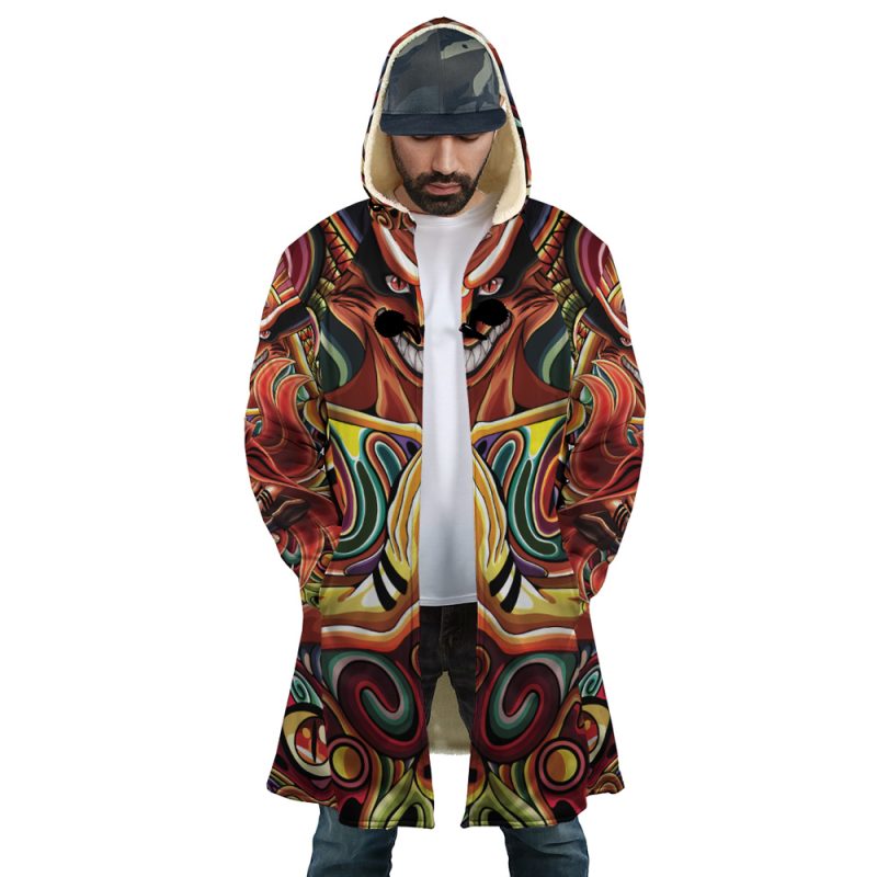 A man stands with hands in pockets, looking down, wearing the Trippy Shippuden Baryon Mode Boruto Dream Cloak Coat—a hooded coat with a bold, colorful abstract face design—along with a cap and white shirt.
