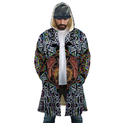 A man wears the Trippy Dungeons & Dragons Dream Cloak Coat—featuring a colorful, intricate geometric and dragon design—over a white shirt and blue pants, standing with hands in pockets and head slightly bowed.