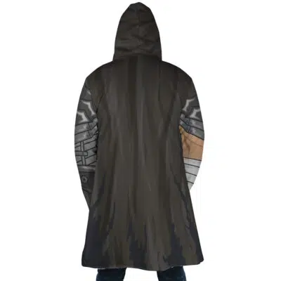 Someone wearing the Guts Armor Berserk Dream Cloak Coat, a long dark hooded coat with metallic robotic arm designs on the sleeves and a subtle pattern on the back, stands facing away from the camera.
