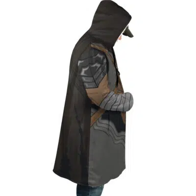 A person, in profile, wears the Guts Armor Berserk Dream Cloak Coat featuring medieval armor-inspired graphics and a hood, paired with a cap and jeans. The background is plain white.