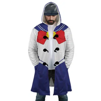 A man wears the Sailor Guardian Sailor Moon Dream Cloak Coat, styled with a blue collar, red bow, gold accents, and white bodice details. He looks down with his hands in his pockets.