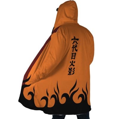 Person seen from behind wearing the Hokage Orange Shippuden Dream Cloak Coat, featuring black flame patterns along the hem and Japanese characters down the back. The hood is up, partly covering their head.