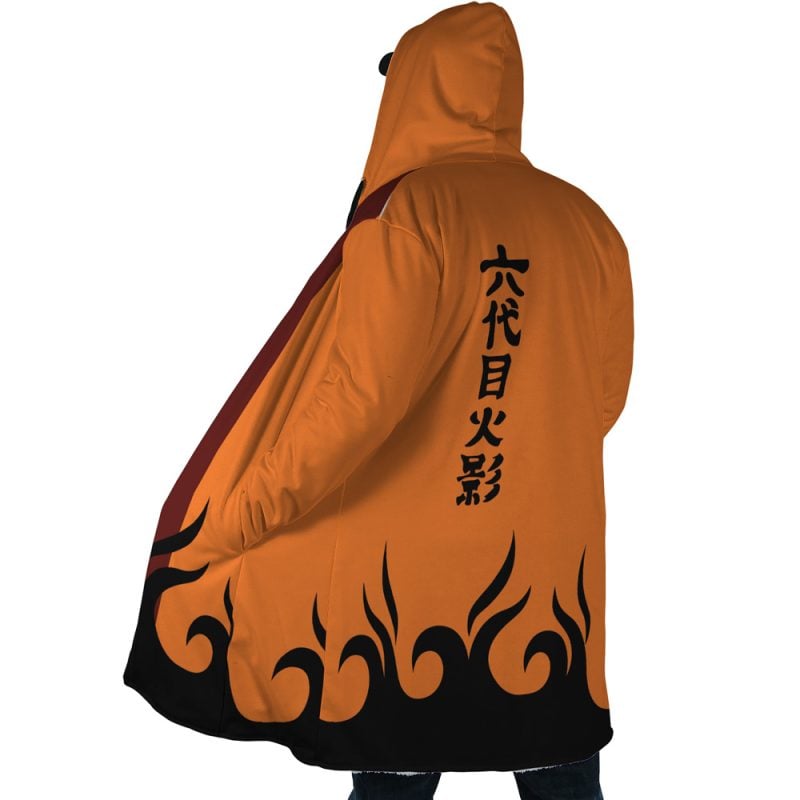 Person seen from behind wearing the Hokage Orange Shippuden Dream Cloak Coat, featuring black flame patterns along the hem and Japanese characters down the back. The hood is up, partly covering their head.