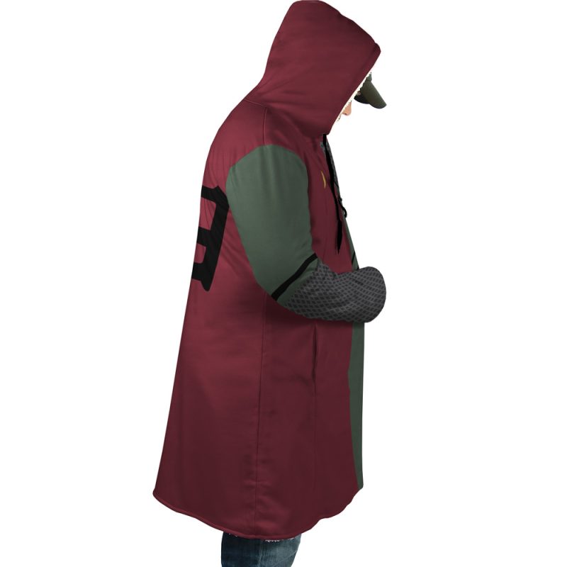 A person wearing the Jiraiya Uniform Shippuden Dream Cloak Coat, featuring maroon and dark green colors with a black number 9 on the back, stands facing left with a bent arm across the chest and their hood concealing most of their face.