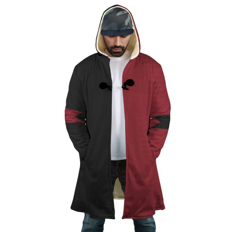 A man wears the Harley Quinn The Suicide Squad DC Dream Cloak Coat—black and maroon with a ribcage chest design and fur lining—paired with a white tee, jeans, and a camo cap, hands in pockets, looking down.