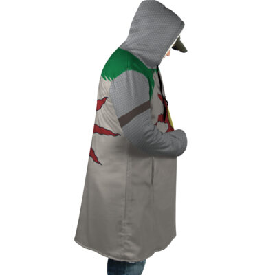 A person wears the Praise the Sun Dark Souls Dream Cloak Coat—knee-length, hooded, with a dinosaur or monster-inspired design in green, gray, and red—standing in profile with hands in pockets.