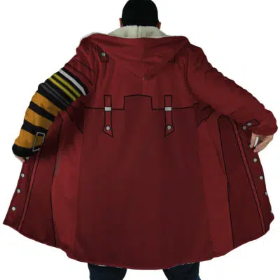 A person faces away, holding open the Vash the Stampede Trigun Dream Cloak Coat. The long red coat features cartoon-like outlined patterns, a fluffy inner collar, and black and yellow striped details on one sleeve.