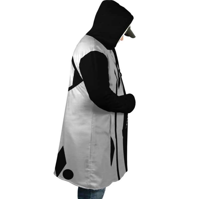 A person stands in profile, hands in pockets, wearing the 1st Division Captain Commander Yamamoto Genryusai Shigekuni Gotei 13 Bleach Dream Cloak Coat—hooded, black and white with abstract geometric patterns.