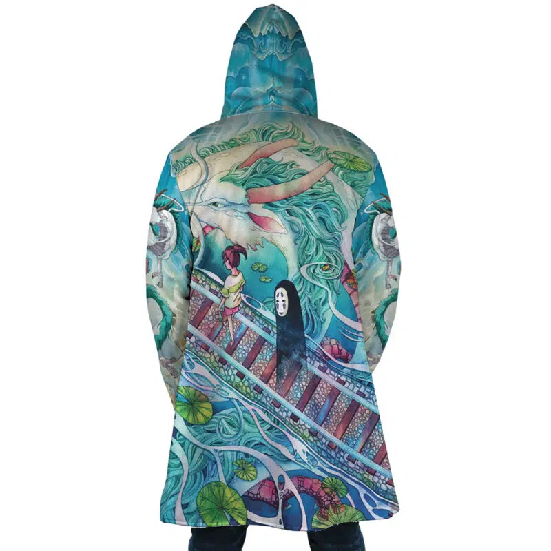 A person wearing the Mythical Spirited Away Studio Ghibli Dream Cloak Coat, featuring vibrant artwork of Chihiro, No-Face, and Haku on a bridge amid swirling water and lily pads.