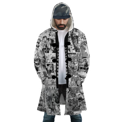 A man wears the Manga Panels Jojo's Bizarre Adventure Dream Cloak Coat, featuring black and white manga comic panels, paired with a white shirt, blue jeans, and a camouflage cap as he looks down with his hands in his pockets.