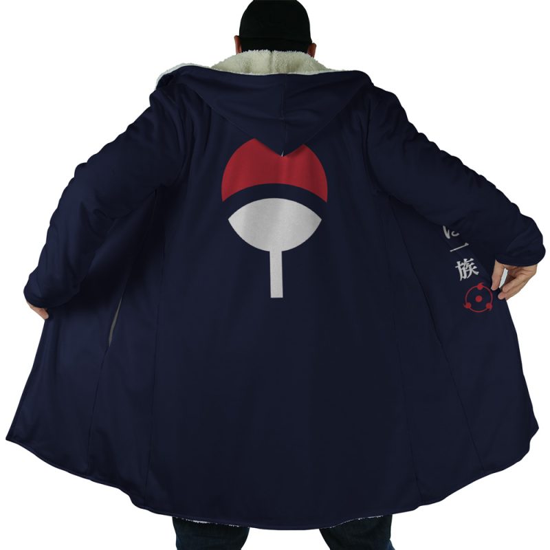 A person wears a long, dark blue Uchiha Clan Sharingan Shippuden Dream Cloak Coat with the Uchiha clan symbol from Naruto on the back. The open coat reveals a light lining and Japanese characters inside.