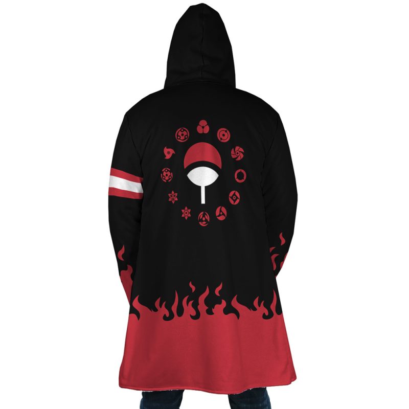 A person wearing the Uchiha Clan Shippuden Dream Cloak Coat, a long black and red hooded coat with flame patterns, white and red arm stripes, and a back design featuring circular red symbols around a large fan emblem.