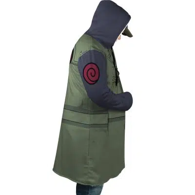 A person stands in profile wearing the Kakashi Hatake Shippuden Dream Cloak Coat—a green hooded cloak with dark sleeves, a red swirl on the arm, and a cap under the hood—resembling attire from the anime Naruto.