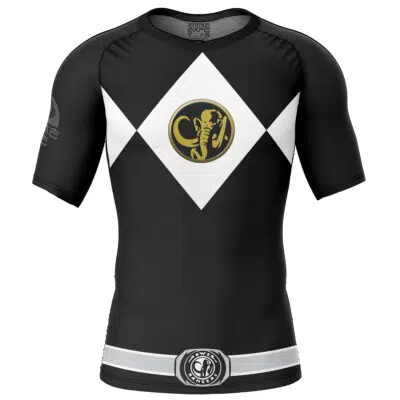 The Black Ranger Mighty Morphin Power Rangers Short Sleeve Rash Guard Compression Shirt features a black design with a white diamond on the chest, gold cobra logo at the center, and white and gray bands near the waist.