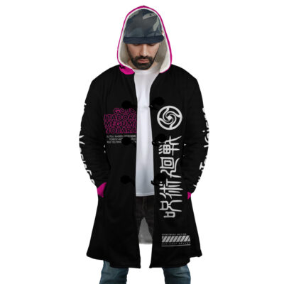 A man wears the Pink Gojo Jujutsu Kaisen Dream Cloak Coat—black with bright pink lining, white Japanese text, and graphics on sleeves and front. He stands looking down, hands in pockets, with a camo cap and gray shirt underneath.