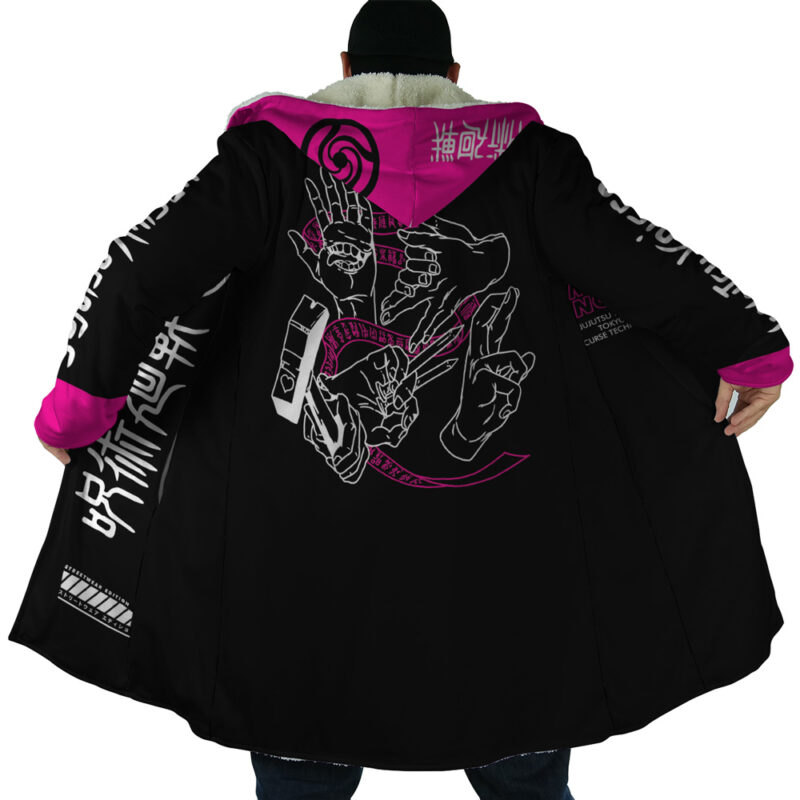 A person wears the Pink Gojo Jujutsu Kaisen Dream Cloak Coat, a long black coat with pink lining and white and pink graphic hand designs plus Japanese text on the back, hood, and sleeves. The coat is open to display its artwork.