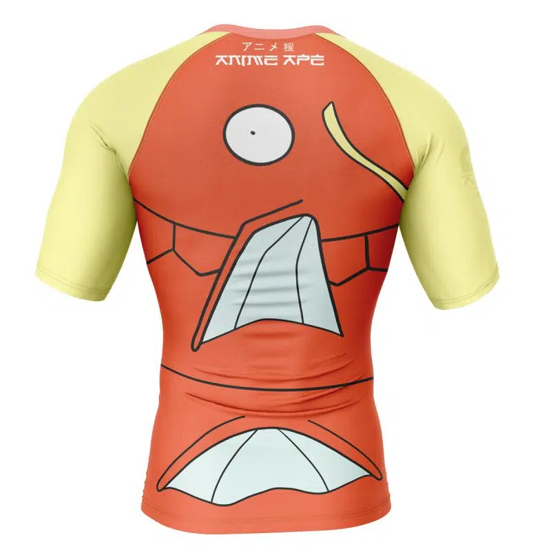 The Magikarp Face Pokémon Short Sleeve Rash Guard Compression Shirt features orange and yellow colors, large eyes, a gaping mouth, Japanese text near the collar, and a cartoon fish face design on the back.