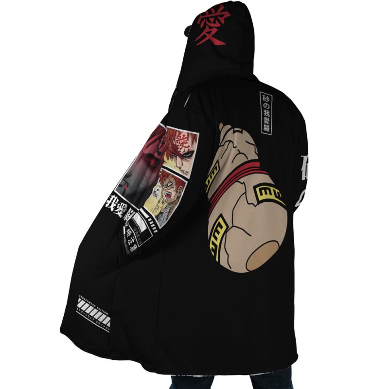 A person wearing the Gaara Shippuden Dream Cloak Coat, featuring bold anime-style graphics with a large hand adorned with rings, manga panels on the sleeve, and Japanese characters on the hood and back, is facing away from the camera.