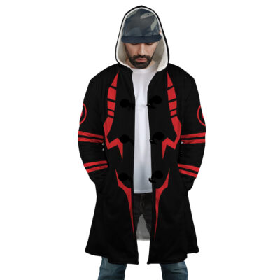 A man wearing the Sukuna Jujutsu Kaisen Dream Cloak Coat with bold red geometric patterns, a white shirt, jeans, and a camouflage cap stands with hands in pockets, looking slightly downward.