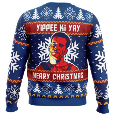 The Yippee Ki Yay Die Hard Ugly Christmas Sweater is a blue sweater with white snowflakes, red and yellow designs, a mans face graphic, and Yippee Ki Yay Merry Christmas printed on the back.