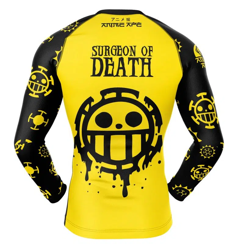 The Trafalgar Law One Piece Long Sleeve Rash Guard Compression Shirt features yellow and black colors, SURGEON OF DEATH, a large smiley logo on the back, and smaller matching logos on the sleeves. Inspired by the anime One Piece.