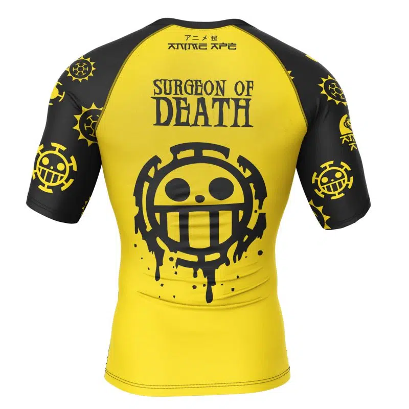 The Trafalgar Law One Piece Short Sleeve Rash Guard Compression Shirt is yellow and black with Surgeon of Death text and a large smiling logo on the back, plus smaller logos and Japanese text on the sleeves and upper back.