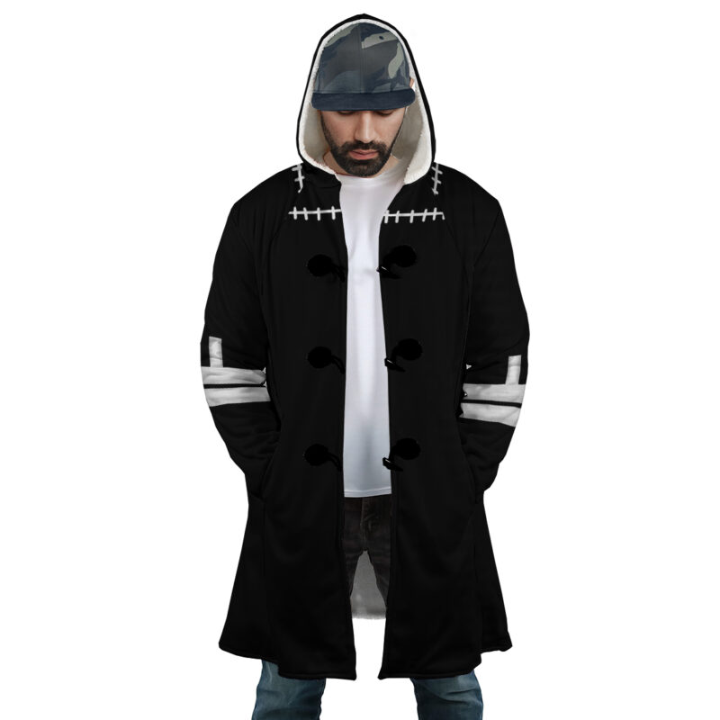 A man wearing the Dabi's Coat My Hero Academia Dream Cloak Coat, featuring black fabric with white stitching and buttons, hands in pockets, a white shirt underneath, and a camouflage cap.