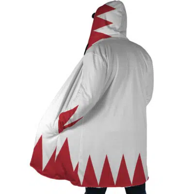 A person wearing the White Mage Final Fantasy Dream Cloak Coat, featuring a white base with red triangular patterns along the bottom and hood, stands with their back to the camera and one hand in a pocket.