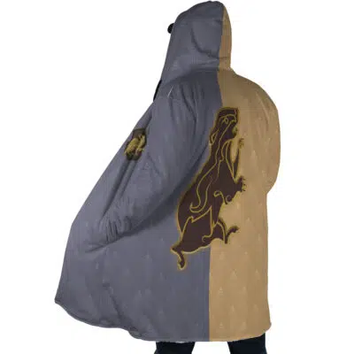 A person wears the Hogwarts Legacy Hufflepuff Harry Potter Dream Cloak Coat, a hooded garment split into gray and tan halves with a large gold and brown lion emblem on the back, subtle patterned fabric, and full-body coverage.