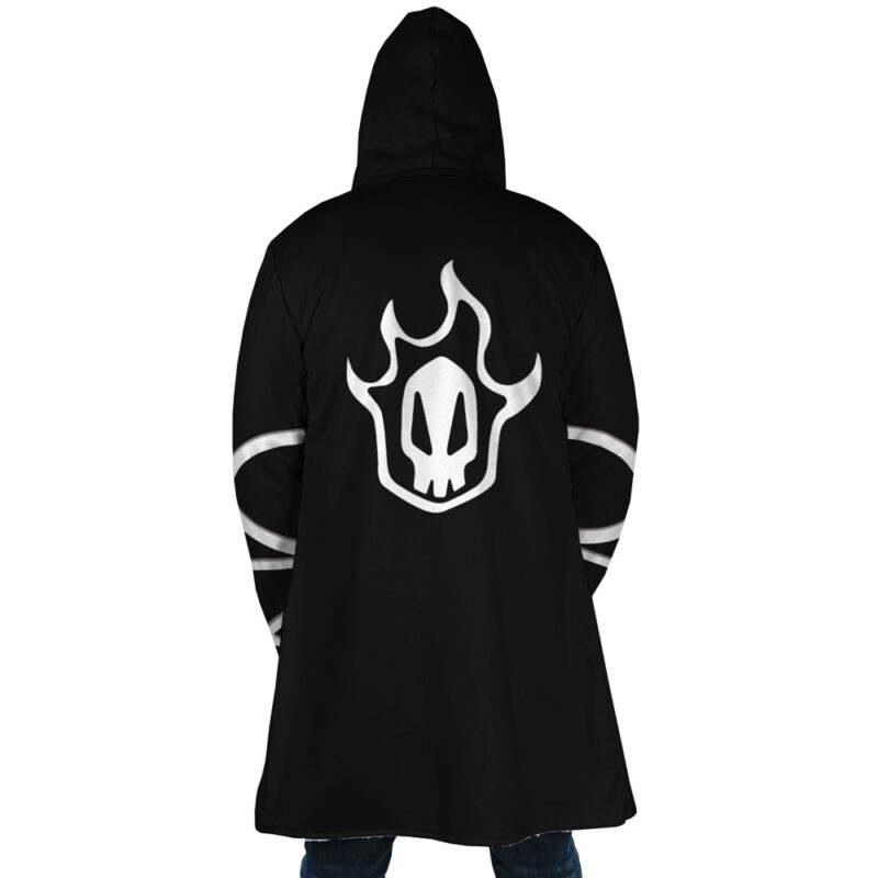A person seen from behind wears the Ichigo Kurosaki Bleach Dream Cloak Coat, a long black hooded coat with a white flame and skull design on the back and white stripes on the sleeves.