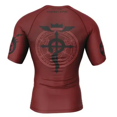 The Edward Elric v2 Fullmetal Alchemist Short Sleeve Rash Guard Compression Shirt is maroon with a large black transmutation circle and symbol on the back, alchemy designs on the sleeves, and the brand name near the collar.