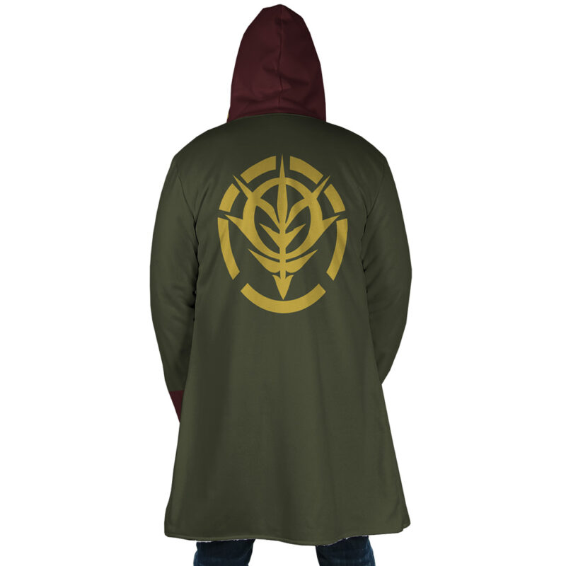 A person is seen from behind wearing the Zeon Uniform Gundam Dream Cloak Coat in olive green with a burgundy hood, featuring a large gold stylized emblem on the back.