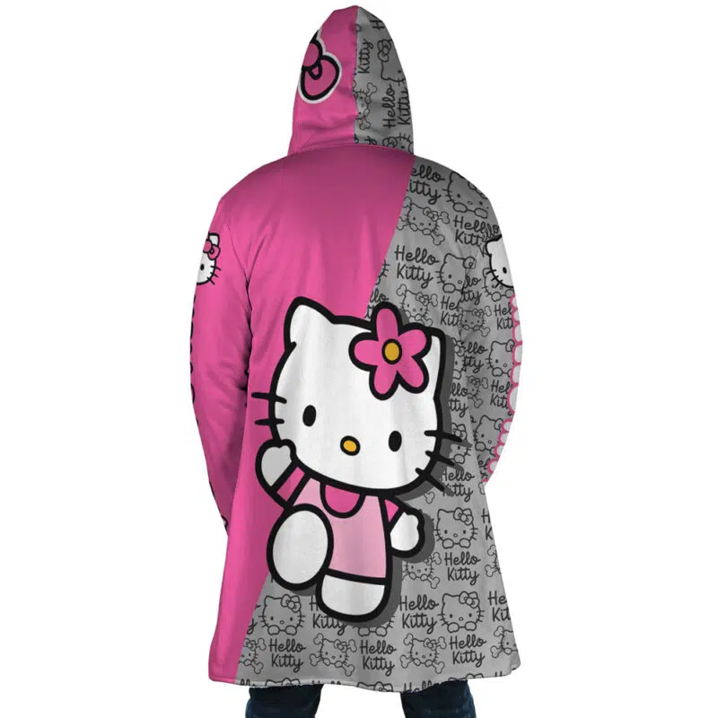 Someone wearing the Hello Kitty Sanrio Dream Cloak Coat—a long, hooded coat. The left side is solid pink with Hello Kitty’s face; the right side is gray with a repeating Hello Kitty pattern and logo.