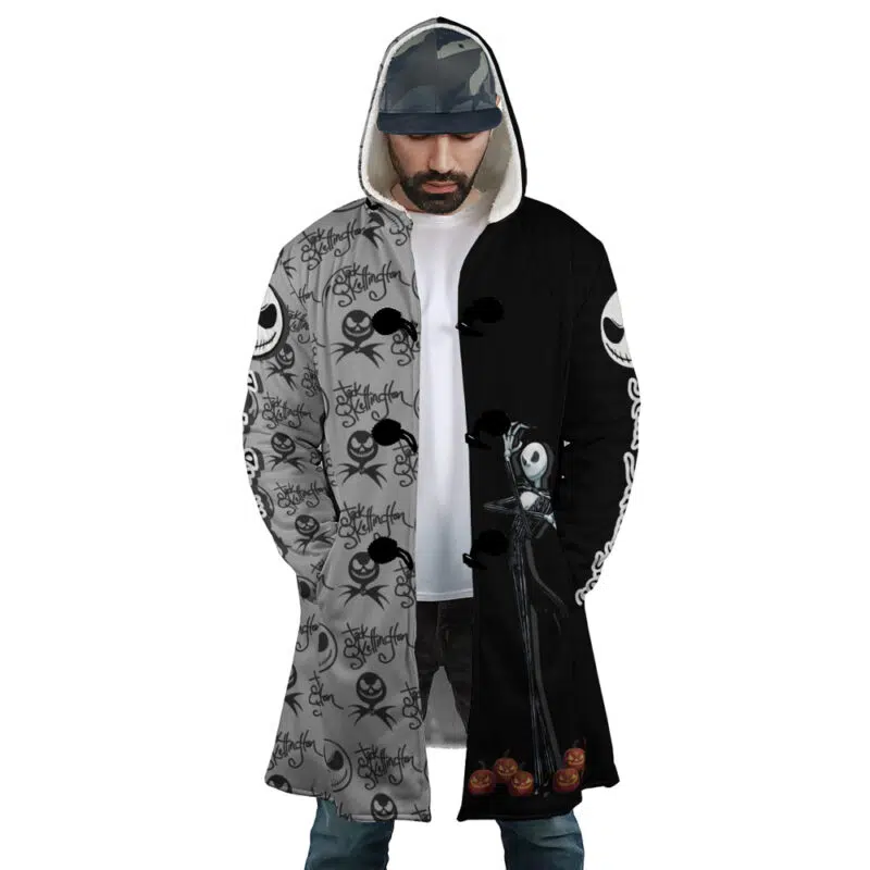 A man wears the Jack Skellington The Nightmare Before Christmas Dream Cloak Coat, a long hooded coat that's half gray with Jack Skellington faces and half black with a large Jack image and small pumpkins at the bottom.