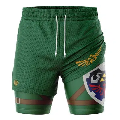 The Link Legend of Zelda 2-in-1 Performance Shorts are green athletic shorts with a drawstring, showcasing a shield print, sword belt design, and a gold crest emblem on the right leg for a heroic look.