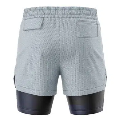 Back view of STARS Resident Evil 2-in-1 Performance Shorts in light gray, featuring an elastic waistband, two back flap pockets, and black compression shorts extending below the hem. The textured fabric looks breathable.