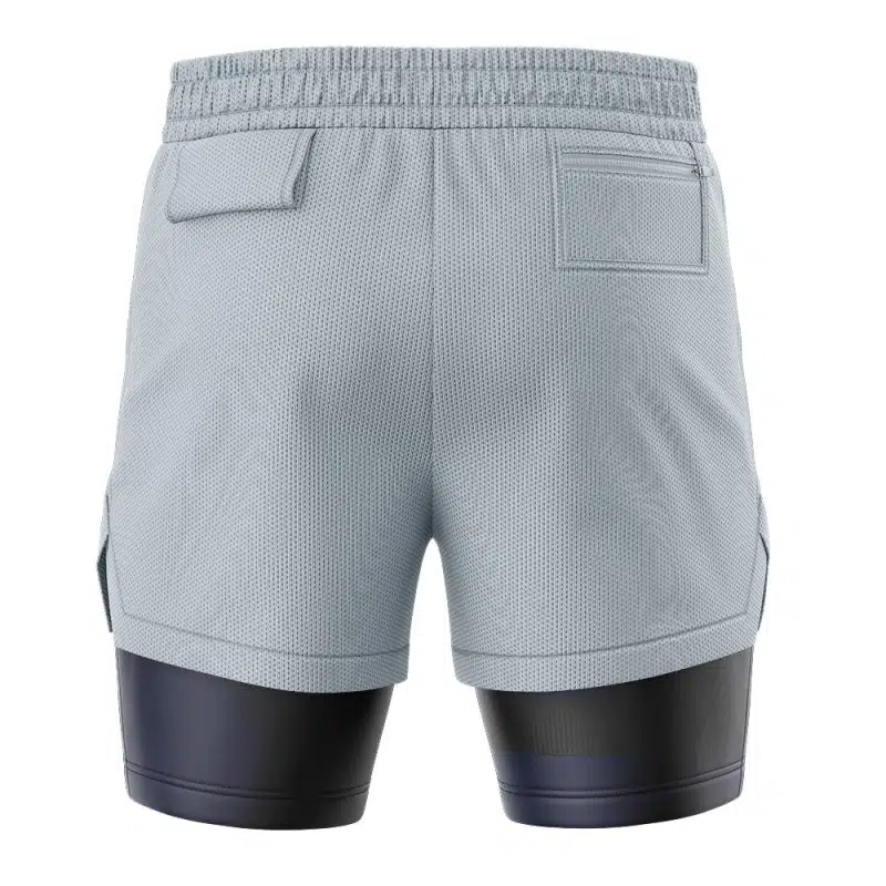 Back view of STARS Resident Evil 2-in-1 Performance Shorts in light gray, featuring an elastic waistband, two back flap pockets, and black compression shorts extending below the hem. The textured fabric looks breathable.