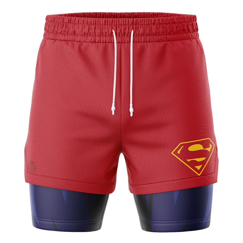 The Superman DC Comics 2-in-1 Performance Shorts feature red athletic shorts with a yellow Superman logo over dark blue compression shorts. The red layer includes white drawstrings and a breathable mesh texture.