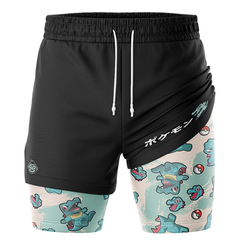 The Totodile Pattern Pokemon 2-in-1 Performance Shorts feature a black layered design with a Totodile and Poké Ball print inner layer, plus white Japanese text and a Totodile graphic on the right side.
