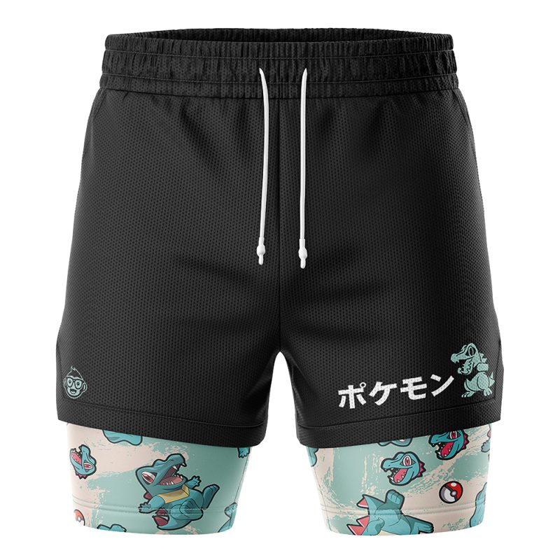Totodile Pattern Pokemon 2-in-1 Performance Shorts feature black athletic shorts with white drawstrings, Japanese Pokémon text, a printed Totodile graphic, and built-in leggings with a repeating Totodile pattern on a light background.