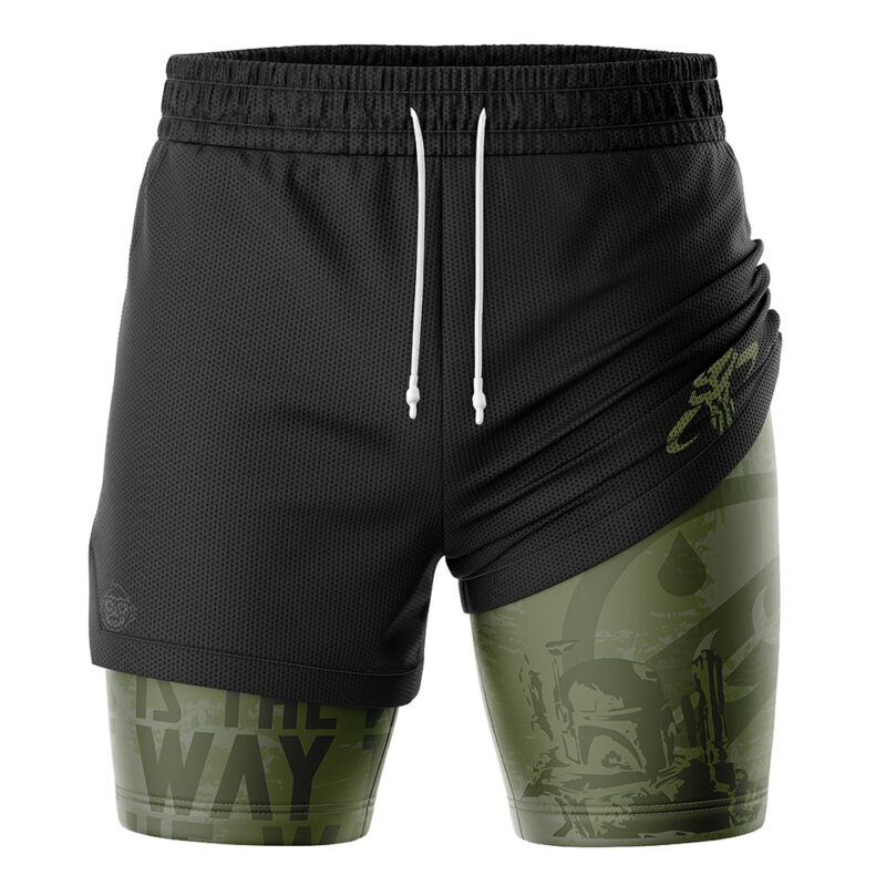The Mandalorian Star Wars 2-in-1 Performance Shorts feature a black outer layer, green inner compression, a subtle Mandalorian helmet with “This is the Way” text, and white drawstrings on the black waistband.