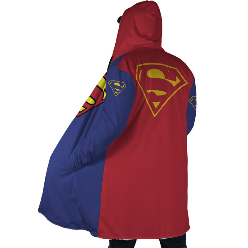 Person seen from behind wearing the Superman DC Comics Dream Cloak Coat, a red and blue hooded robe featuring large yellow Superman logos on the back, shoulder, and arm. The robe is loosely draped with the hood up.