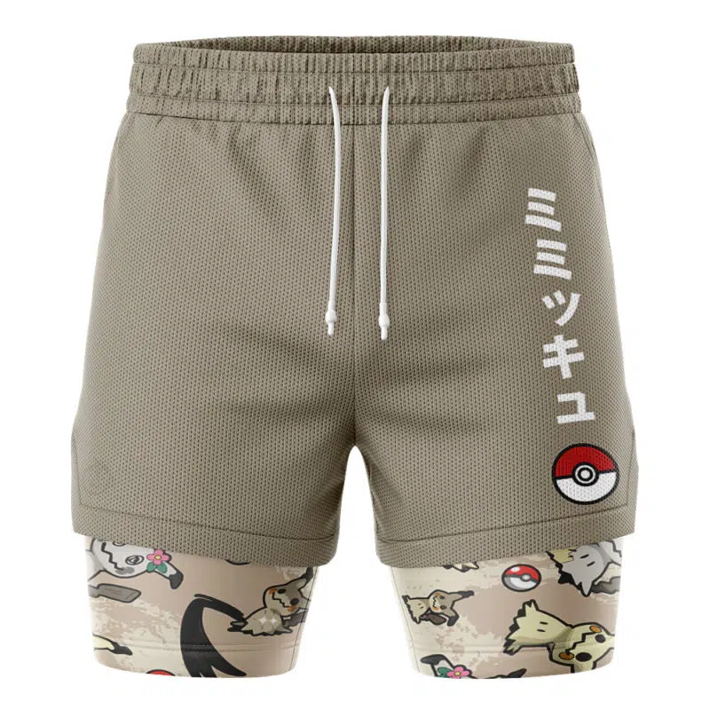 The Umbreon Trippy Pokemon 2-in-1 Performance Shorts feature khaki athletic shorts with white Japanese text and a Poké Ball graphic, layered over beige compression shorts with playful Pokémon and Poké Ball patterns.