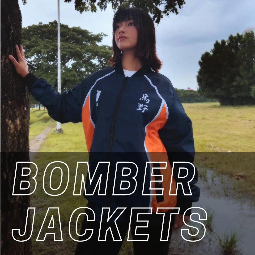 A person wearing a blue bomber jacket with orange and white stripes stands outdoors on a rainy day. The words BOMBER JACKETS are displayed in bold text across the bottom of the image.